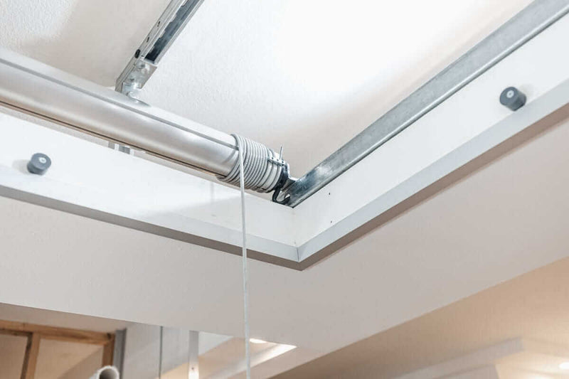 Interior view showing the Auxx Attic Lift in action, with the platform lifting items into a spacious attic storage area