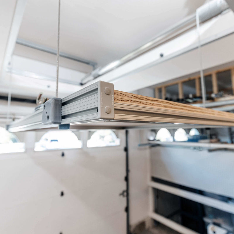Close-up of the Auxx Attic Lift’s motorized lifting system, showcasing the durable cables and motor unit in action
