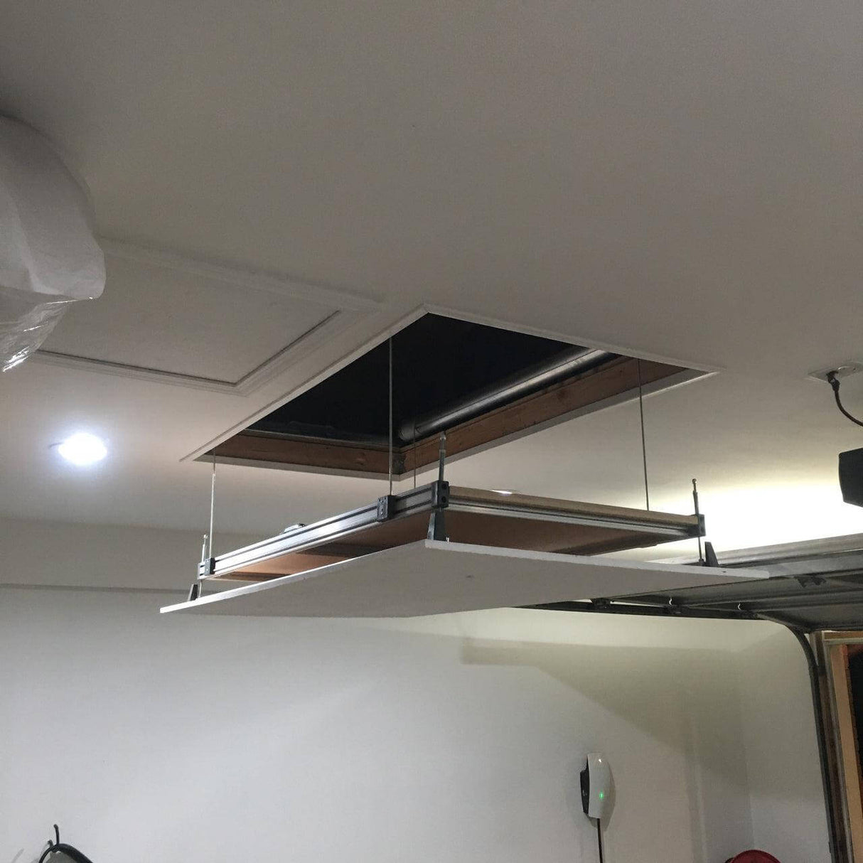 Side view of the Auxx Attic Lift in operation, showing the platform raising items into the attic space