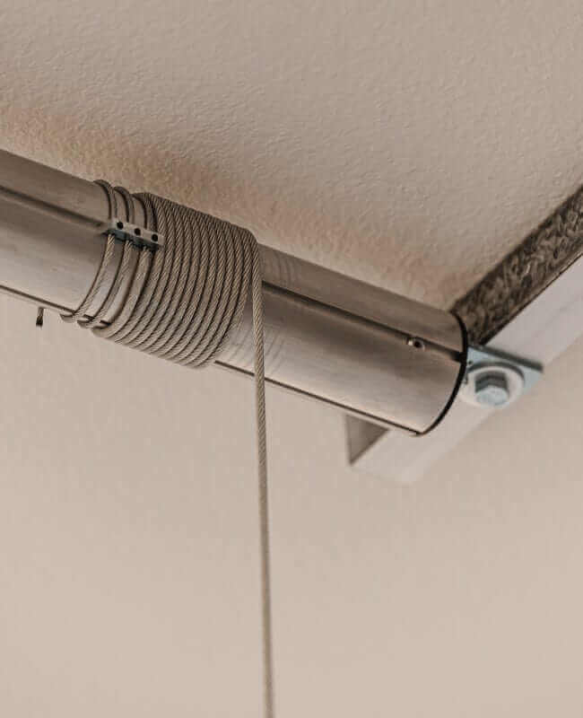 Side view of the Auxx Lift installed in a garage, showcasing its compact design and efficient use of overhead space