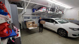 Wide garage view featuring the Auxx Lift fully loaded with items, demonstrating vertical storage efficiency