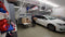 Wide garage view featuring the Auxx Lift fully loaded with items, demonstrating vertical storage efficiency