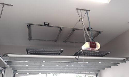 The Auxx Lift mid-operation, shown partially lowered with visible cable tension and platform alignment